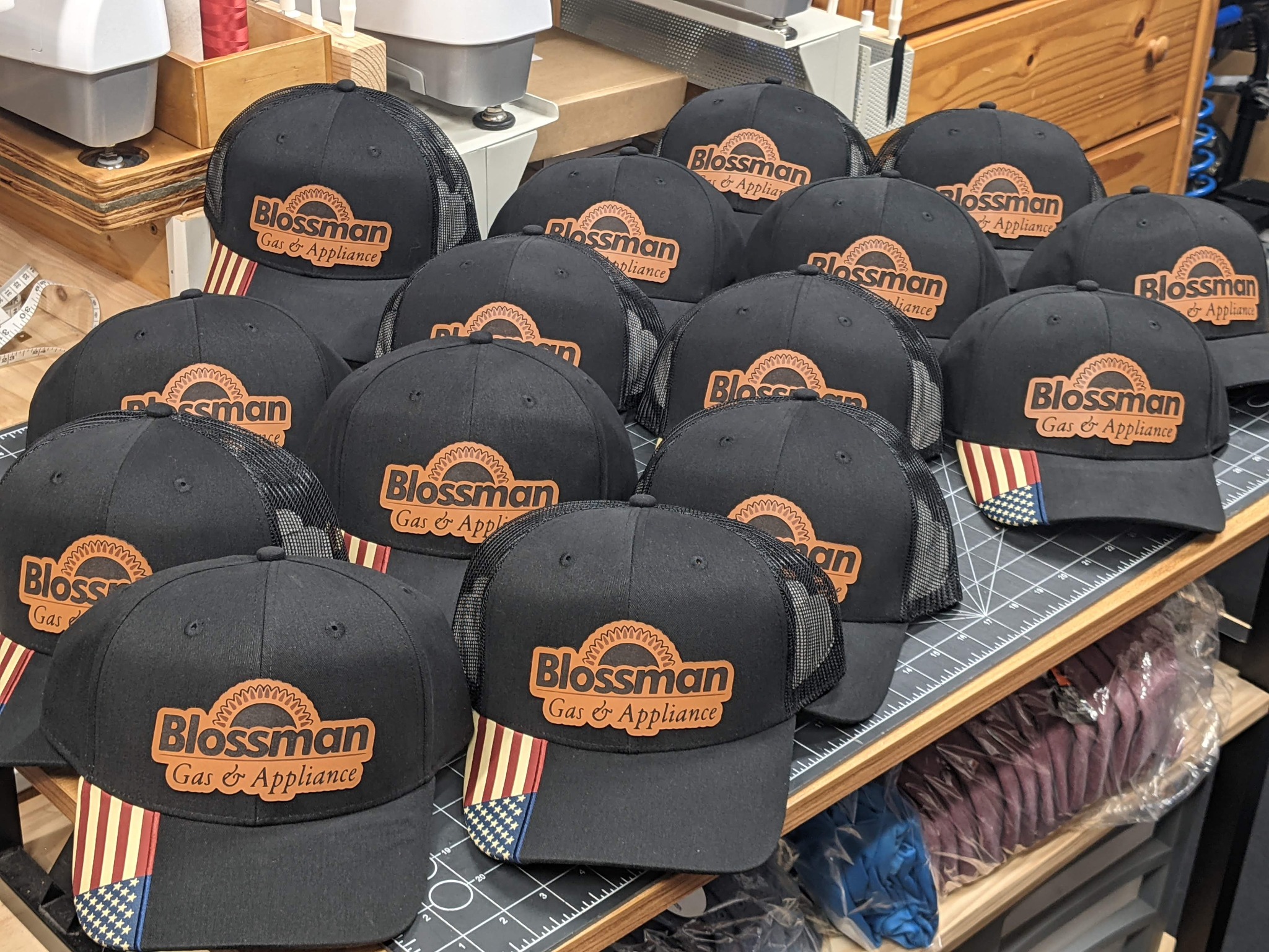 Batch of black Blossman Gas and Appliance caps with matching company logo leather patches