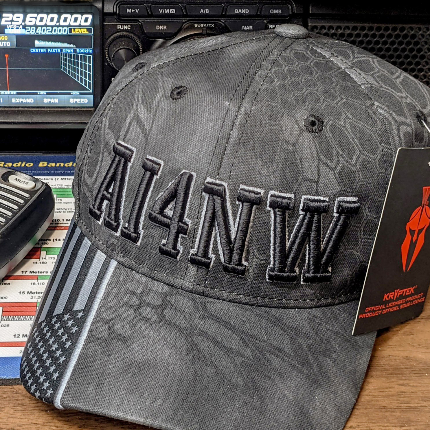 AI4NW custom embroidered Kryptek ham radio cap beside radio equipment
