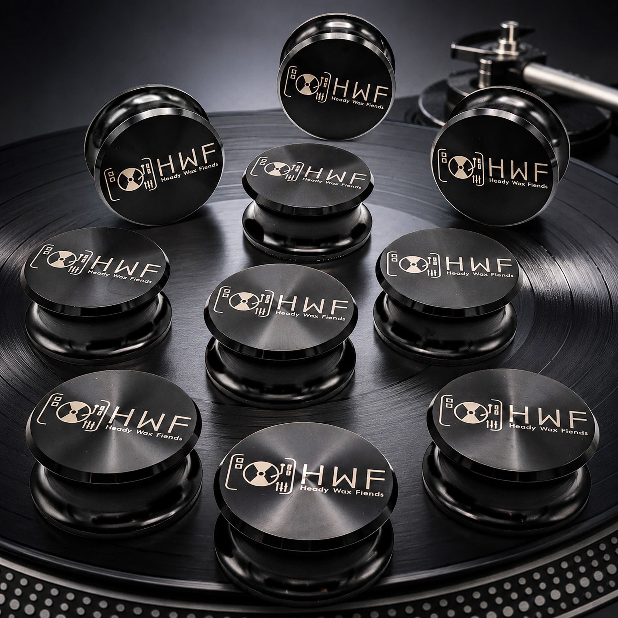 Group of black record weights engraved with the HWF Heady Wax Fiends logo