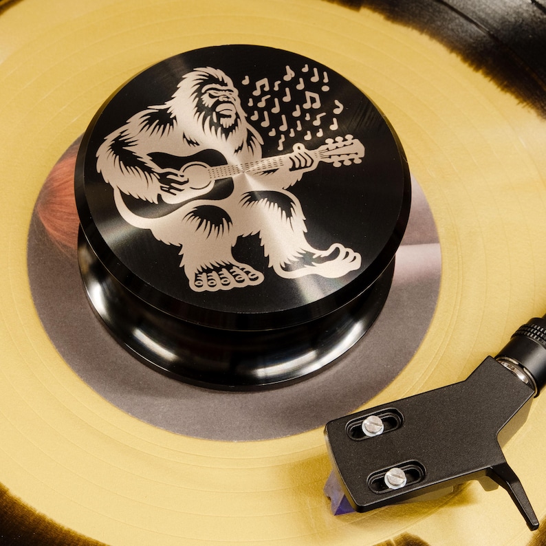Bigfoot playing guitar engraved on a black record weight
